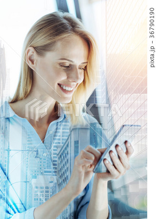 Young joyful lady having break and using her Young joyful lady having break and using her 36790190