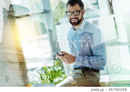 Pleasant joyful man using the smartphone and Pleasant joyful man using the smartphone and 36790268
