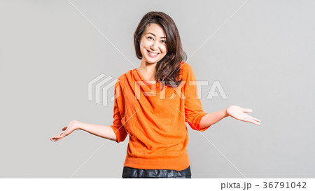 オレンジ色の服を着た女性 スタジオ撮影の写真素材