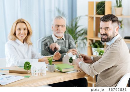 Positive cheerful engineers smiling while having a Positive cheerful engineers smiling while having a 36792881