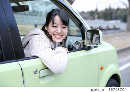 車の窓から顔を出す女の子の写真素材