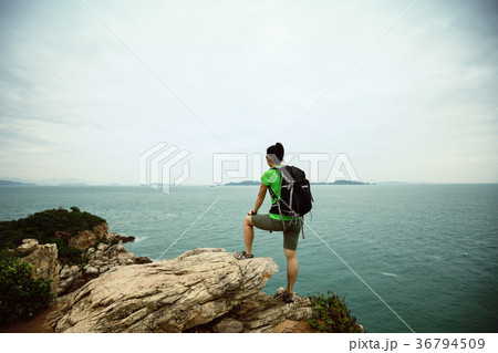 woman enjoy the view on seaside mountain top cliff woman enjoy the view on seaside mountain top cliff 36794509