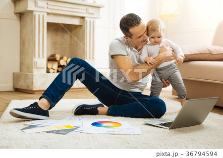 Professional designer hugging his baby child while 36794594