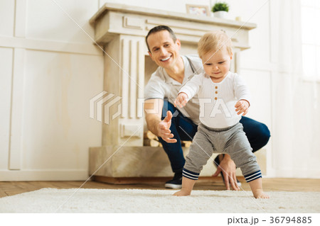 Happy baby trying to stand up while a cheerful Happy baby trying to stand up while a cheerful 36794885