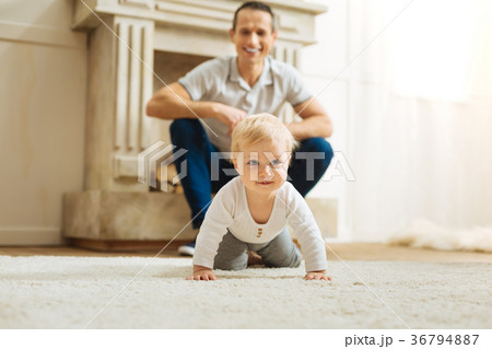 Pretty baby smiling while trying to crawl on the 36794887