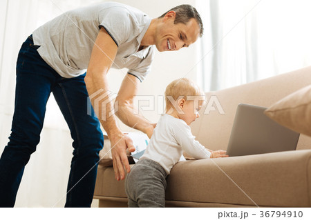 Curious baby exploring the items on a sofa while a 36794910