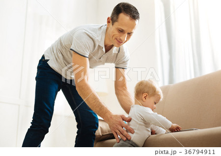 Adorable kind father helping his baby to stand 36794911