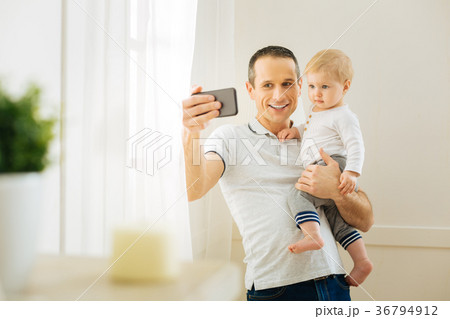 Kind father taking photos with a baby while 36794912