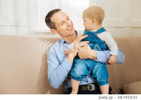Attentive baby looking at his father while sitting 36795035