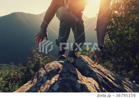 one woman hiker climbing rock on mountain top one woman hiker climbing rock on mountain top 36795159