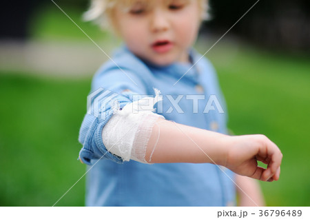 Cute little boy looking on his elbow with applied bandage 36796489