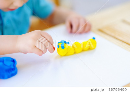 Creative boy playing with colorful modeling clay at kindergarten 36796490