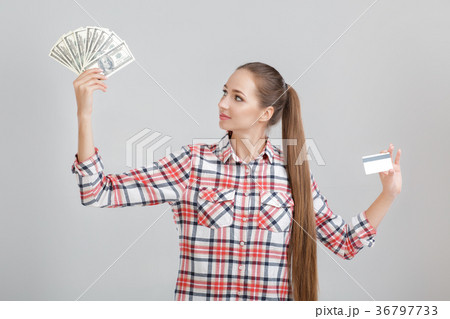 woman holds dollar bills and plastic card. woman holds dollar bills and plastic card. 36797733