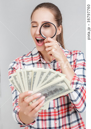 woman looks in magnifier on dollar bills woman looks in magnifier on dollar bills 36797760