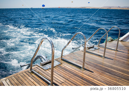 yacht's stern with two boarding ladders.azure sea 36805510