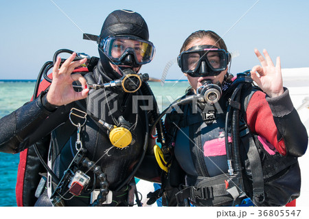 two happy divers in wetsuits show ok. Hobby two happy divers in wetsuits show ok. Hobby 36805547