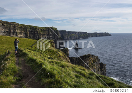 Ireland, Clare County, Woman looking at view on Cliffs of Moher 36809214