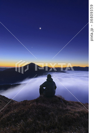 Ukraine, Zakarpattia region, Rakhiv district, Carpathians, Chornohora, Tourist sitting on mountain meadow at dusk 36809359