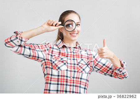 woman looks through a magnifying glass woman looks through a magnifying glass 36822962