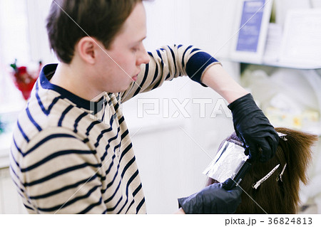 the hairdresser in the salon makes hair coloring 36824813