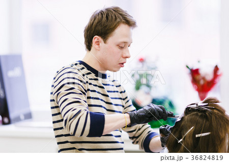 the hairdresser in the salon makes hair coloring 36824819