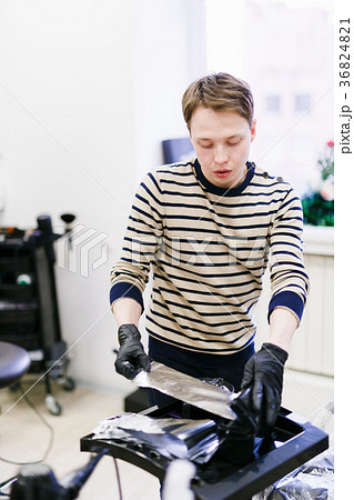 the hairdresser in the salon makes hair coloring 36824821
