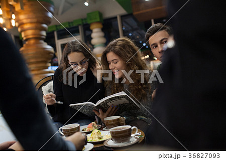 Group of teenagers doing homework in cafe. Group of teenagers doing homework in cafe. 36827093