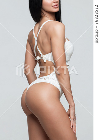 Slim tanned woman's body over gray background 36828522