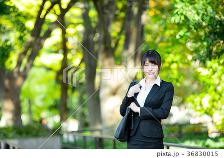 スーツ姿の成人女性 Ol オフィスレディ ビジネス スーツ ポートレート リクルート 緑背景 の写真素材