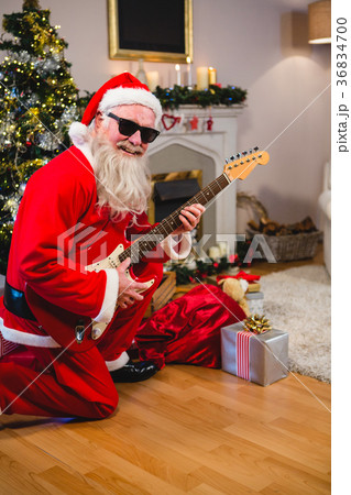 Smiling santa claus playing a guitar Smiling santa claus playing a guitar 36834700