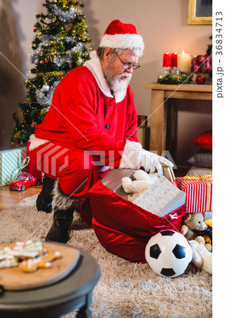 Santa claus listening music on mobile phone at home 36834713