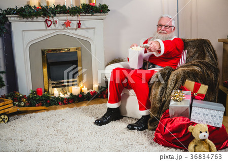 Santa Claus holding television remote control Santa Claus holding television remote control 36834763