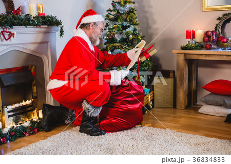 Santa Claus reading scroll in living room Santa Claus reading scroll in living room 36834833