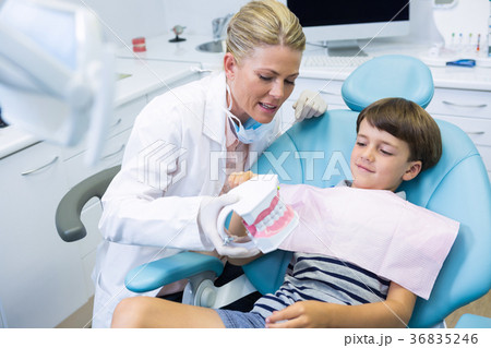 Dentist holding dental mould while talking with boy 36835246
