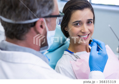 Woman smiling while receiving dental treatment at clinic Woman smiling while receiving dental treatment at clinic 36835319
