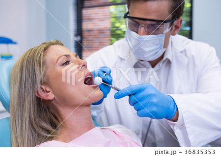Close-up of doctor wearing surgical mask examining patient Close-up of doctor wearing surgical mask examining patient 36835353