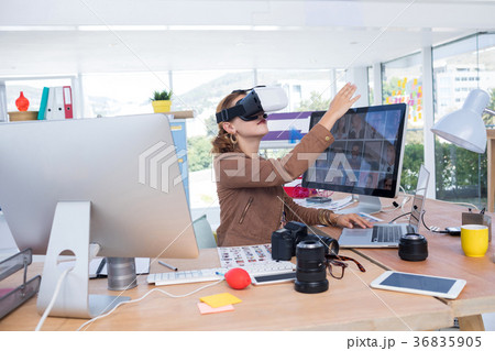 Female executive working on laptop while using virtual reality headset 36835905