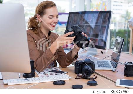 Female executive reviewing captured photograph at her desk 36835965