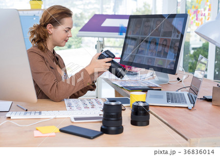 Female executive reviewing captured photograph at her desk 36836014