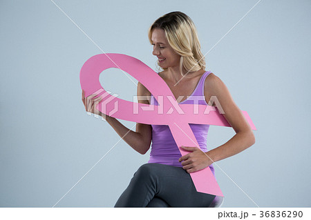 Smiling woman holding Breast Cancer Awareness ribbon 36836290