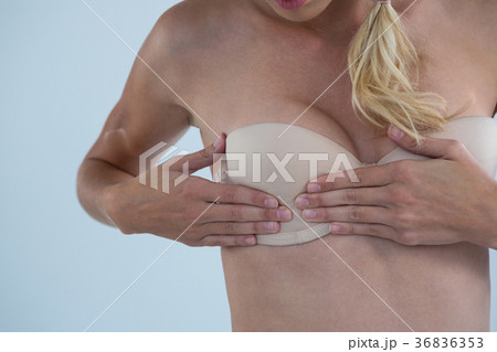 Mid section of woman checking breast for lumps 36836353