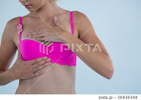 Woman with Breast Cancer Awareness ribbon checking lumps while touching breast Woman with Breast Cancer Awareness ribbon checking lumps while touching breast 36836368