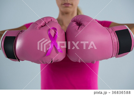 Mid section of woman with boxing gloves and pink ribbon 36836588