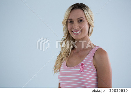 Portrait of smiling young female in tank top with pink ribbon Portrait of smiling young female in tank top with pink ribbon 36836659