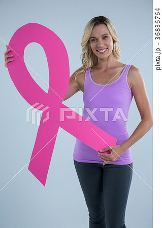 Portrait of young female showing cardboard Breast Cancer Awareness ribbon Portrait of young female showing cardboard Breast Cancer Awareness ribbon 36836764