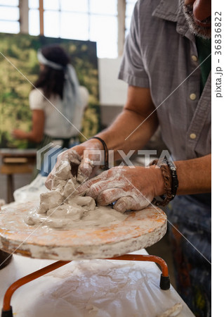 Mid section of man molding clay 36836822