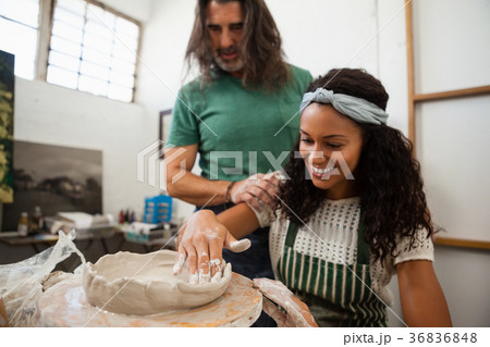 Man assisting woman in pottery 36836848