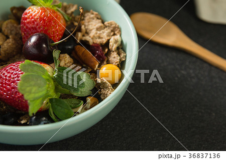 Bowl of breakfast cereals with fruits on black background 36837136