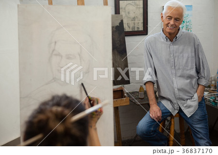 Senior man watching while artist drawing on canvas 36837170
