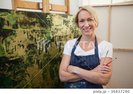 Portrait of smiling woman standing with arms crossed Portrait of smiling woman standing with arms crossed 36837280